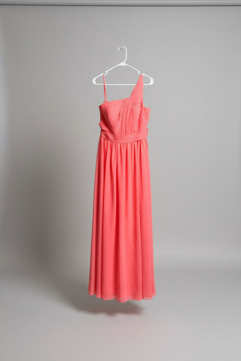 A coral pink sleeveless maxi dress hanging on a white hanger next to a metal garment rack outdoors on grass, with a house and window visible in the background.