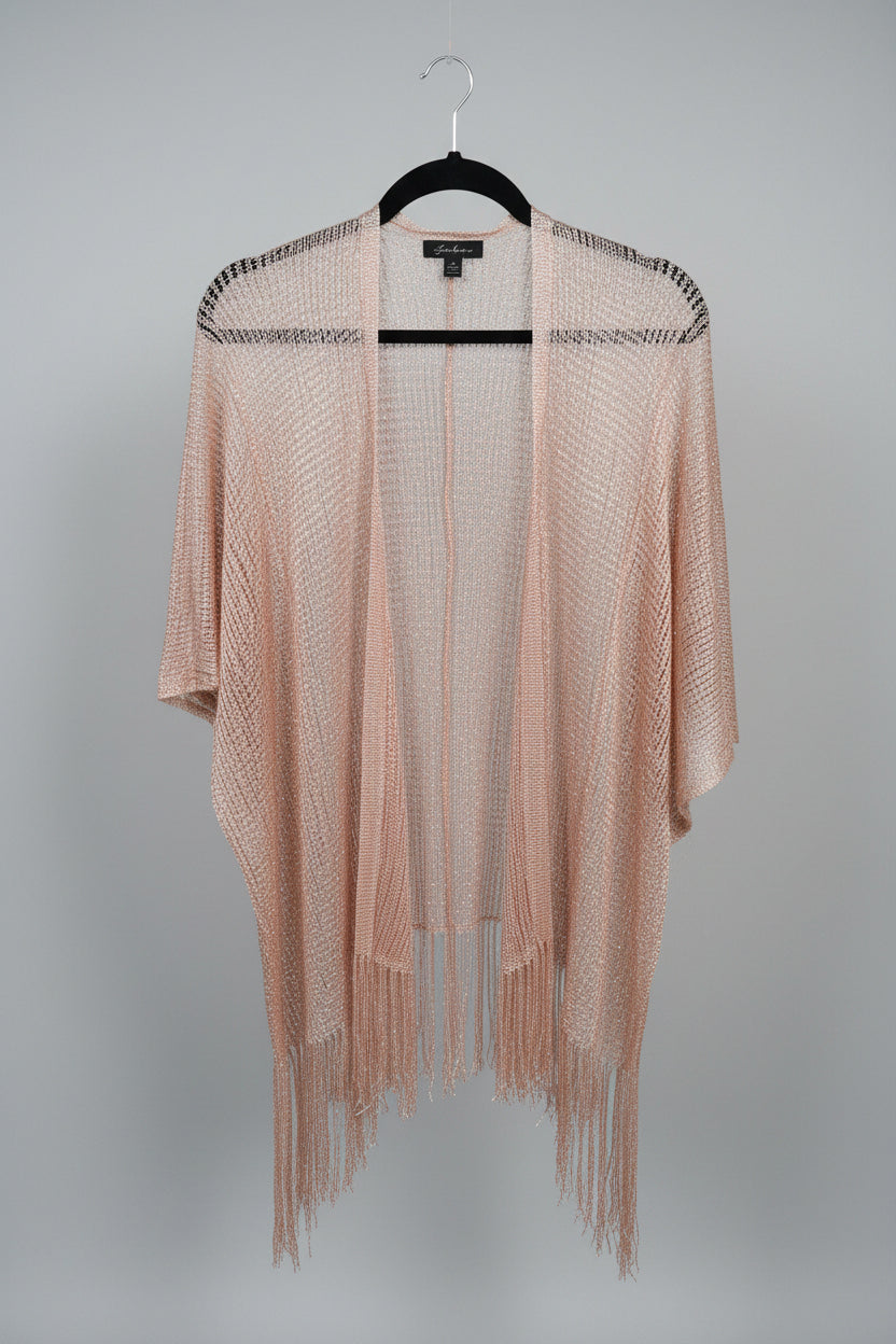 A shimmering metallic rose gold open-front cardigan with fringe details, hanging on a black hanger on a clothing rack alongside other garments.